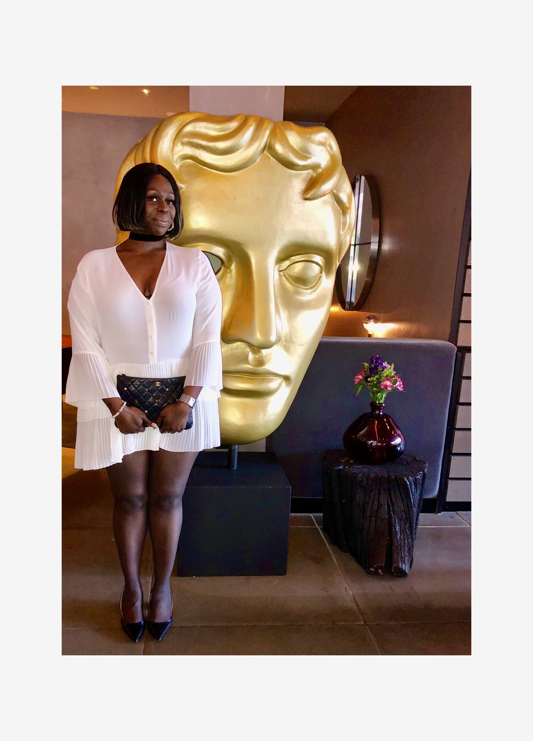 Marlena Harris Morgan at a BAFTA event with the gold BAFTA mask